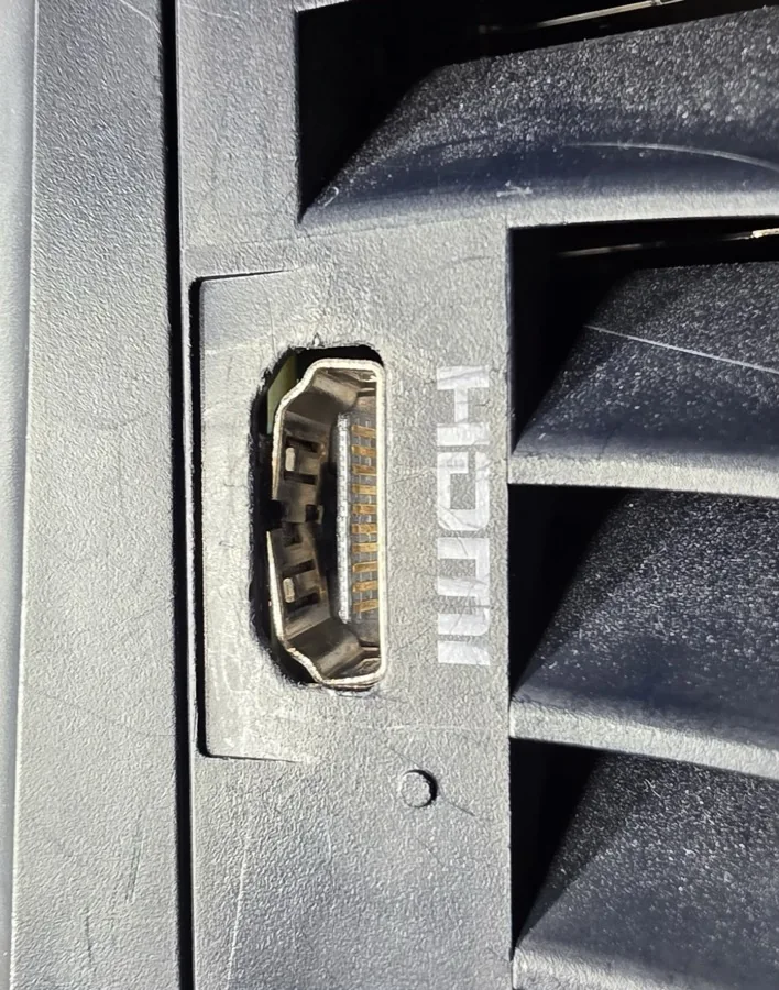 A PS5 HDMI port with bent internal contact pins and a cracked shell, caused by a yanked cable